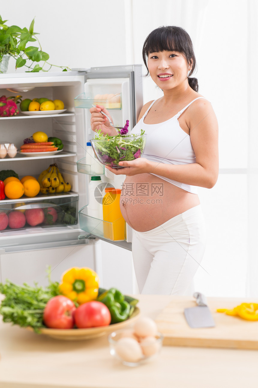身体关注健康生活方式户内孕妇打开冰箱拿蔬菜图片