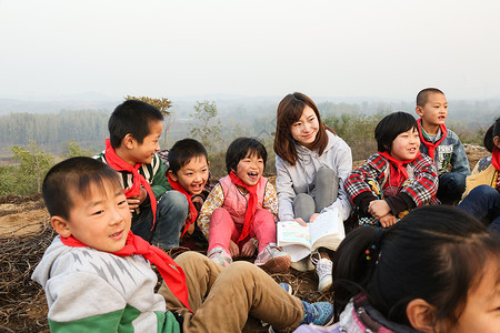 坐着看书孩子坐着彩色图片知识乡村教师和小学生在户外学习背景