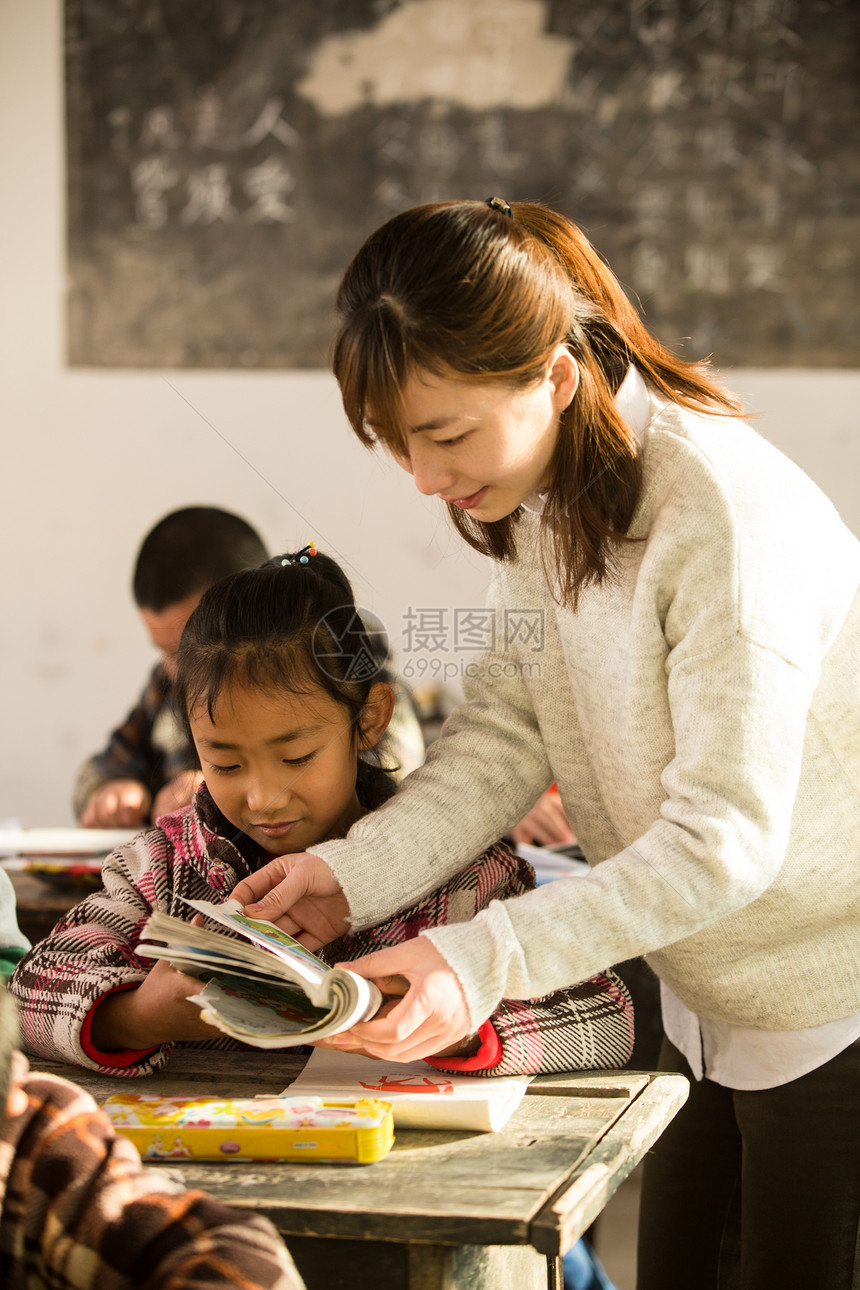 希望小学教育成年人乡村女教师和小学生在教室里图片