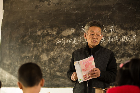 逆境乐观乡村男教师和小学生在教室里图片