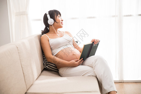 轻松生长起居室孕妇听音乐看书图片