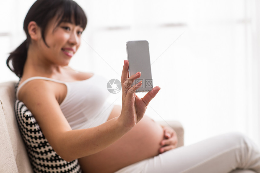 孕育露出肚子孕妇用手机自拍图片