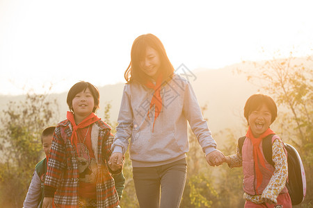 乡村孩子女生青年女人欢乐乡村女教师和学生在户外背景