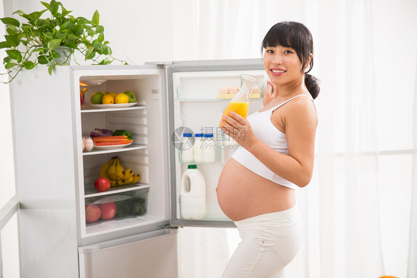 露出肚子保护自信孕妇打开冰箱拿果汁图片
