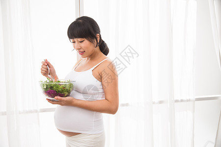 住宅房间健康的舒适幸福的孕妇吃蔬菜沙拉图片