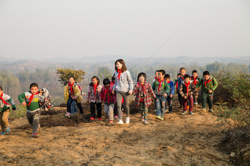 东方人快乐小学女生乡村女教师和学生在玩耍图片