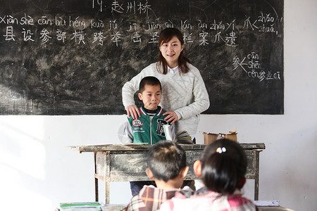 男孩青年女人渴望乡村女教师和小学生在教室里图片
