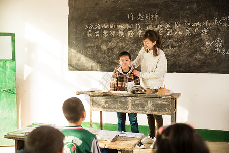 关爱东方人责任乡村女教师和小学生在教室里图片