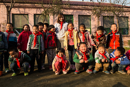 破旧的团队乡村教师和小学生在学校里图片