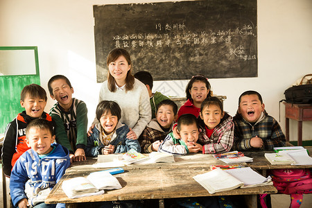 外国女教师指导教师学龄儿童可爱的乡村女教师和小学生在教室里背景