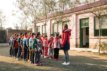 列队男孩小学女生团结乡村教师和小学生在学校里背景