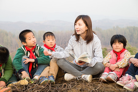 青年人相伴乐观乡村教师和小学生在户外学习高清图片