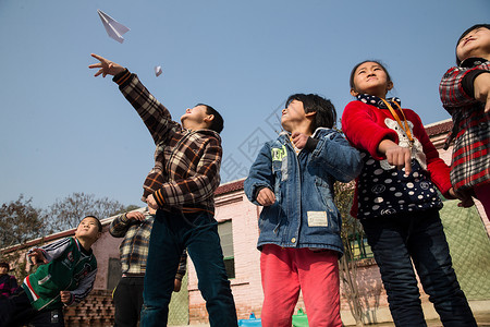 信心待遇户外乡村小学生在学校放纸飞机图片