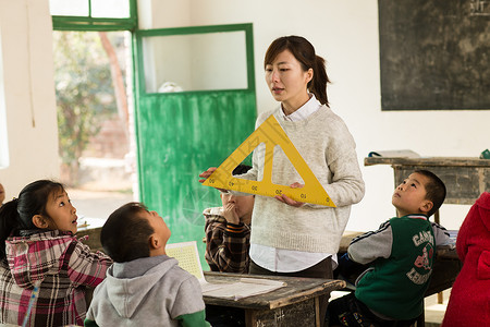 可爱三角形东方人信心学习乡村女教师和小学生在教室里背景