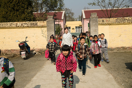 小学生相伴希望乡村女教师和学生在户外图片