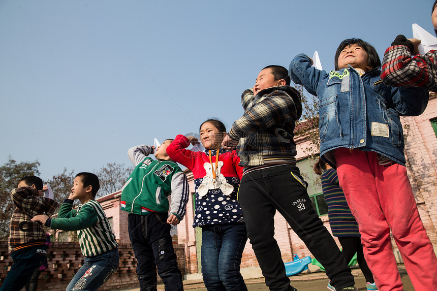 人儿童农村乡村小学生在学校放纸飞机图片