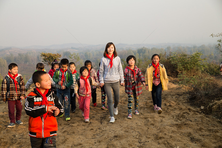 户外活动关爱奔跑乡村女教师和学生在玩耍图片