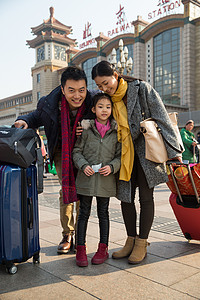 中年游客母亲春运休闲装幸福家庭在火车站背景