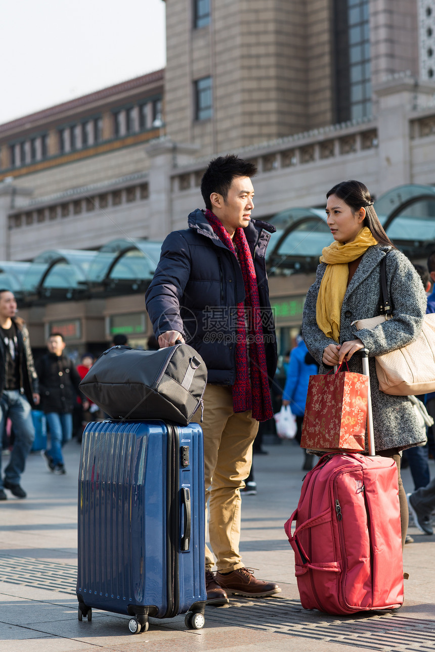 旅行的人围巾购物袋青年男女在站前广场图片