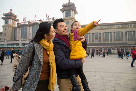 旅途拉杆箱过年幸福家庭在站前广场高清图片