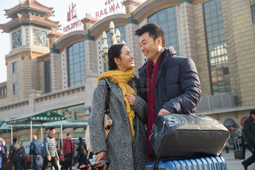 旅行箱运输大楼成年人青年男女在站前广场图片