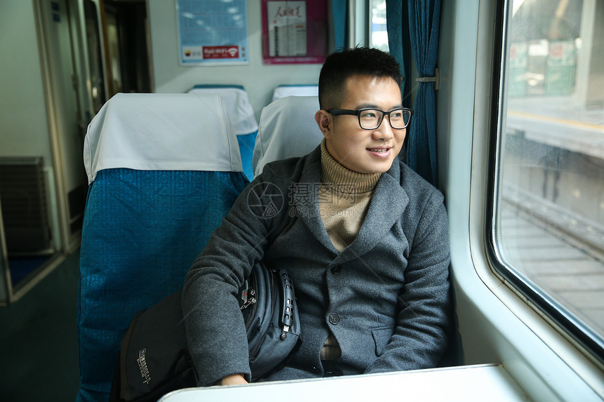 车窗离开春运青年男人在火车上图片