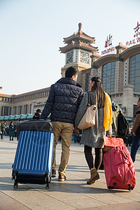 中年游客摄影回家旅游青年男女在站前广场背景