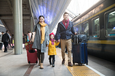 旅途春节厚衣服幸福家庭在车站月台图片