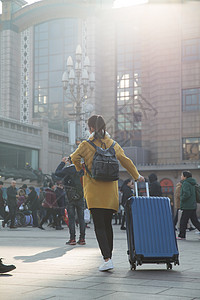 回家旅行者行李青年女人在站前广场图片