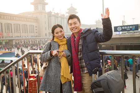中年游客摄影出发亚洲人青年男女在站前广场背景