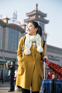 旅行箱春运度假青年女人在站前广场图片