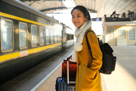 等火车的人休闲装乘客等青年女人在车站月台背景