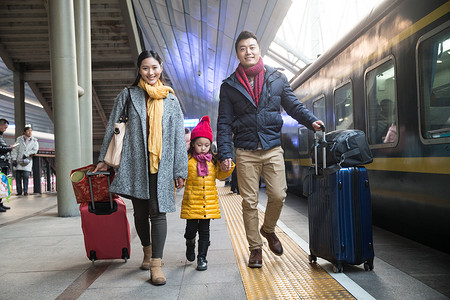 表现积极东方人厚衣服幸福家庭在车站月台高清图片