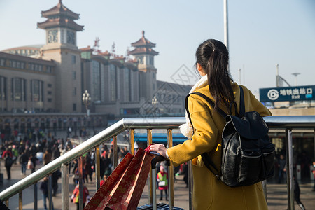 拿着旅游度假青年女人在站前广场图片