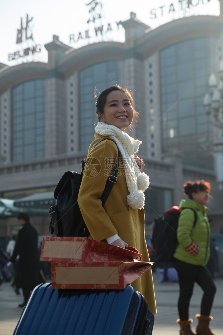旅行箱东亚幸福青年女人在站前广场图片
