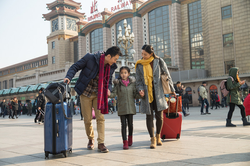 探亲旅行箱女孩幸福家庭在火车站图片