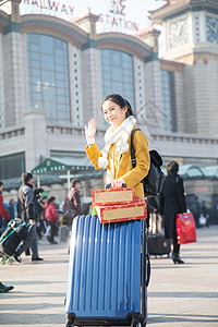 旅游亚洲人拿着青年女人在站前广场图片