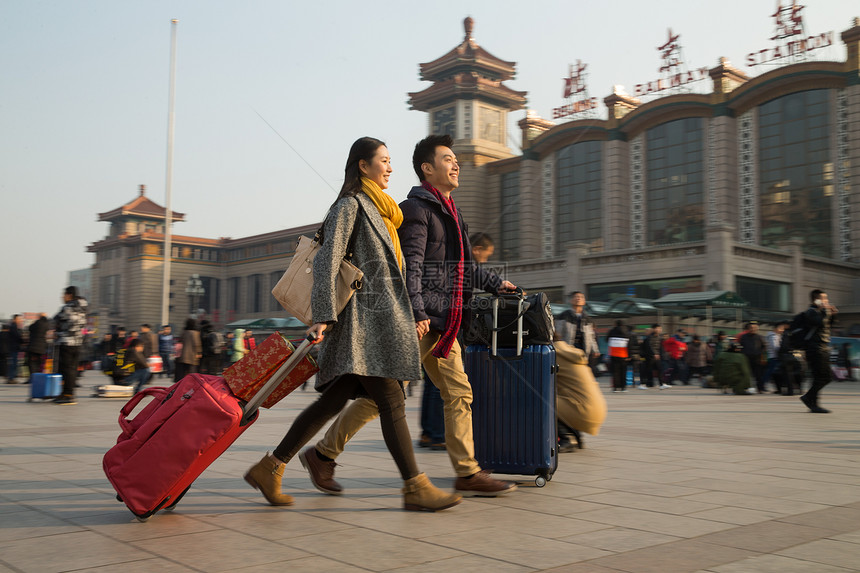 背包客中年人亚洲人青年男女在站前广场图片