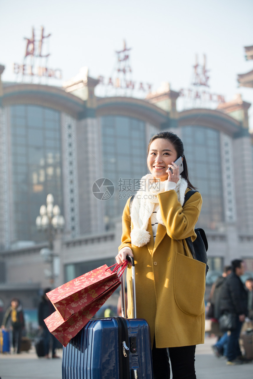 表现积极休闲装购物袋青年女人在站前广场图片