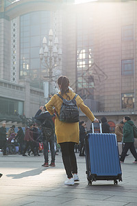 旅行箱乘客户外青年女人在站前广场图片