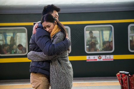 青年人东亚拥抱年轻情侣在火车站背景图片