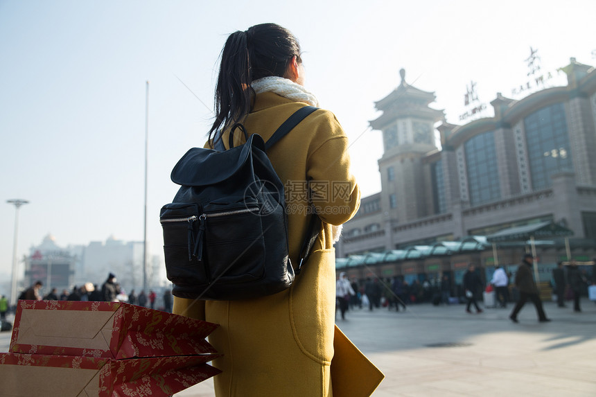 背包客春运白昼青年女人在站前广场图片