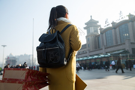 背包客春运白昼青年女人在站前广场图片
