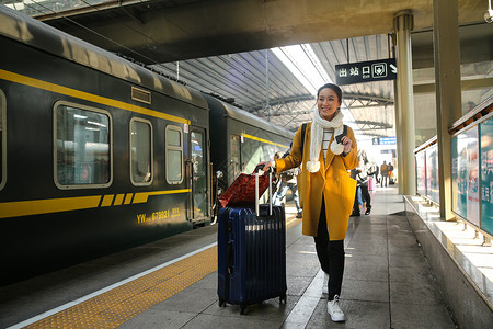 表现积极拉杆箱漂亮的人青年女人在车站月台图片