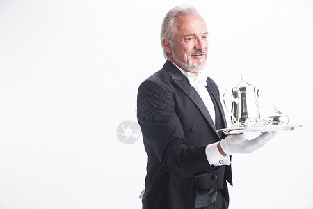 银级服务手套摄影60到64岁一个男侍者托着银餐具背景
