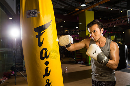 竞争对拳灯光东方人锻炼青年男人在健身房里健身背景