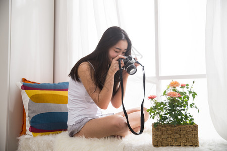 青年女人拿着相机拍照图片