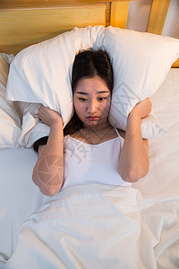 悲痛青年人东方人摄影情绪低落的青年女人在卧室的床上背景