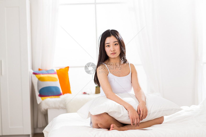青年女人坐在床上图片
