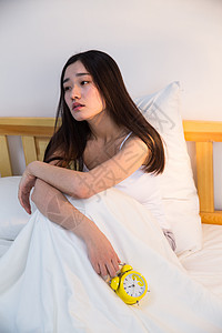 住房压力棉被人独处情绪低落的青年女人在卧室的床上背景